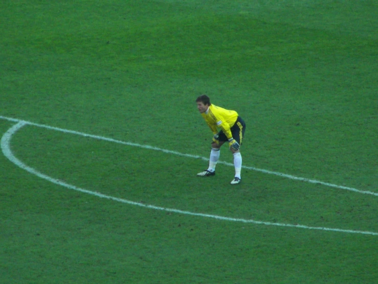 the soccer player in yellow is getting ready to kick a ball