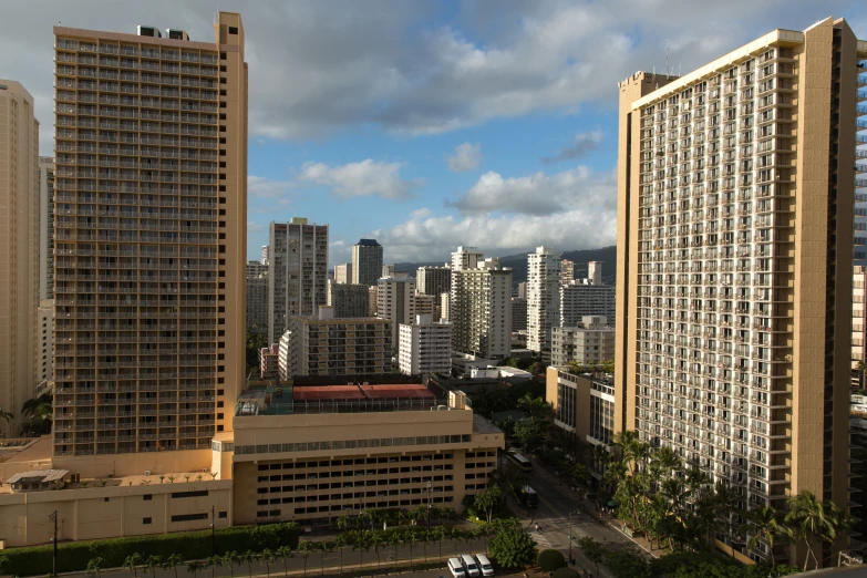 a group of tall buildings in the city with other buildings and some cars