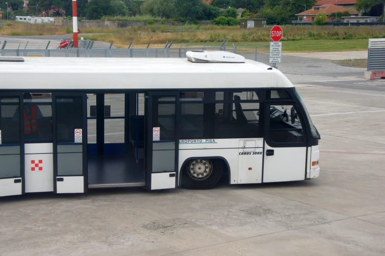 an electric passenger bus parked next to a fence