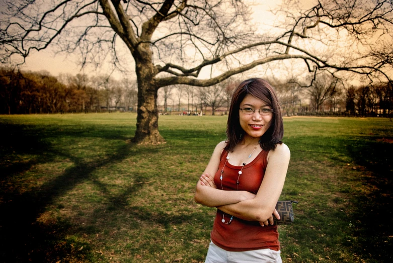 a woman standing in front of a tree