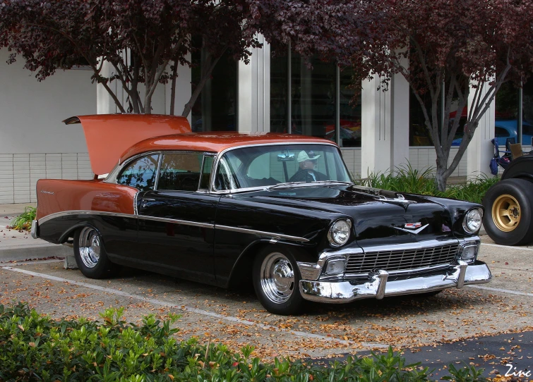 an old classic car sits in a parking lot