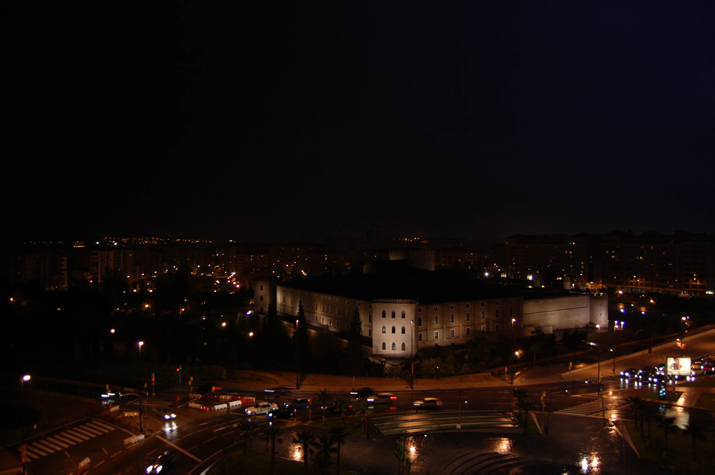 a street view with buildings lit up in the dark