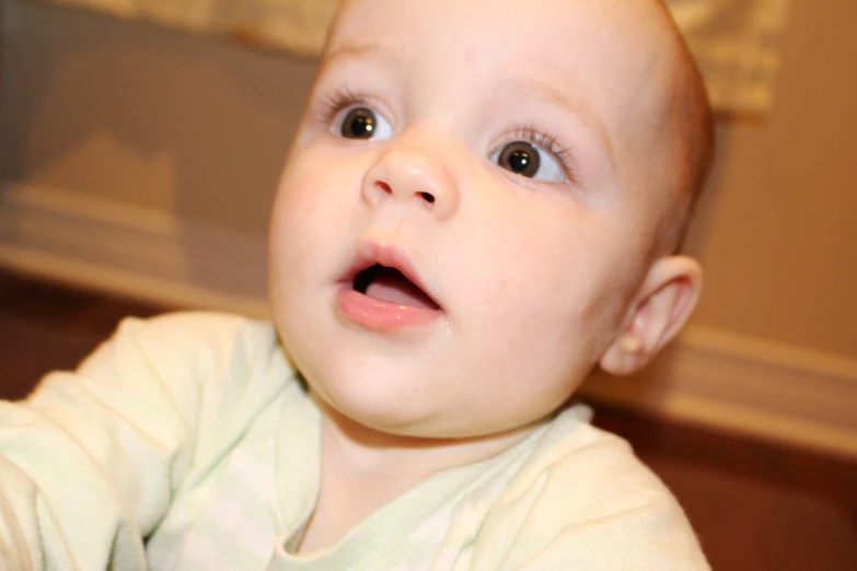 a baby looking up with an opened mouth