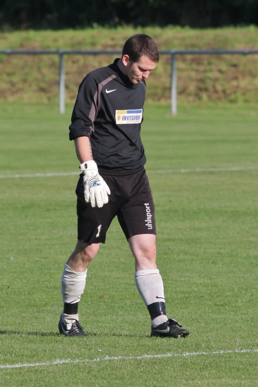 a soccer player wearing his protective gear is looking down