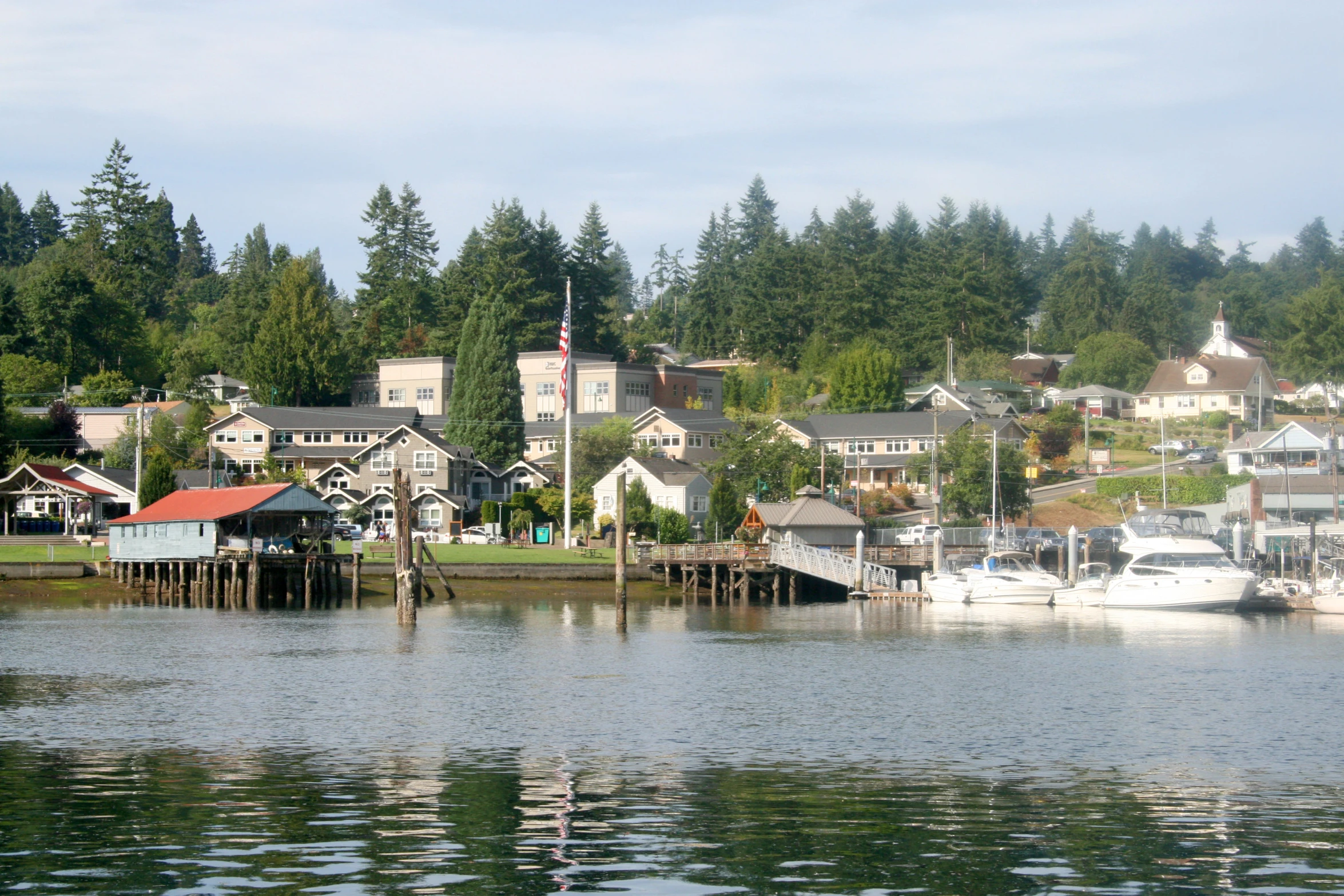 several boats are on a river with a city behind them