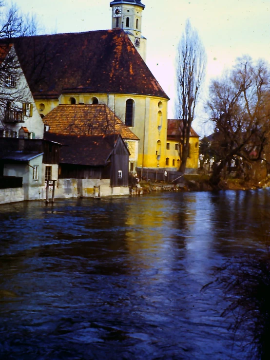 the river is running near a small church