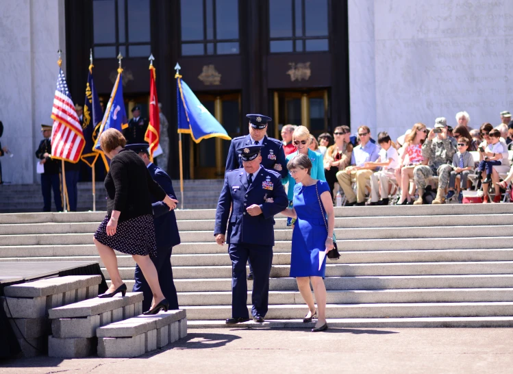 two uniformed people are standing on some steps