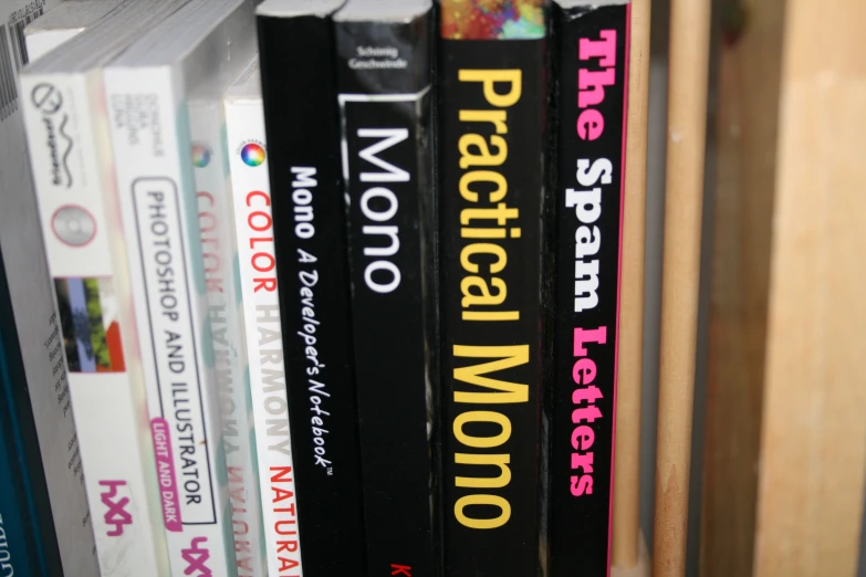 a book shelf filled with black books with yellow lettering