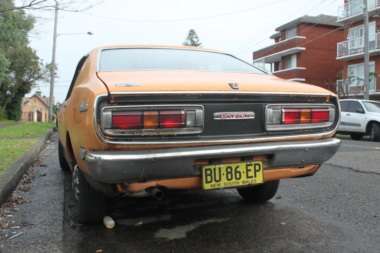 an old orange car parked in a lot