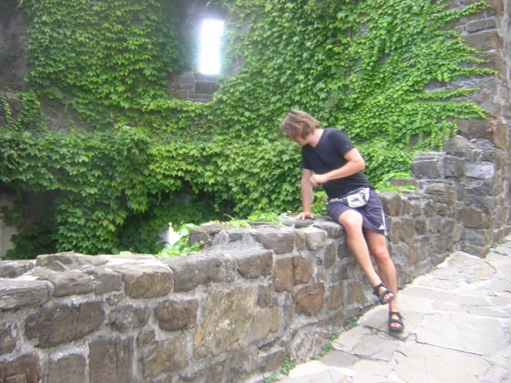 a person standing on the side of a stone wall