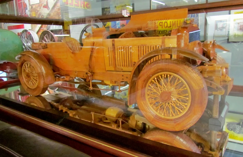 an antique yellow automobile on display in a shop