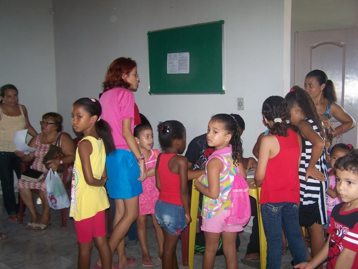 group of children watching a girl do dance in front of a man