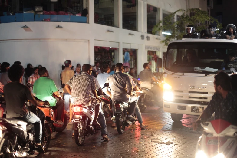 people on motor bikes in the street at night