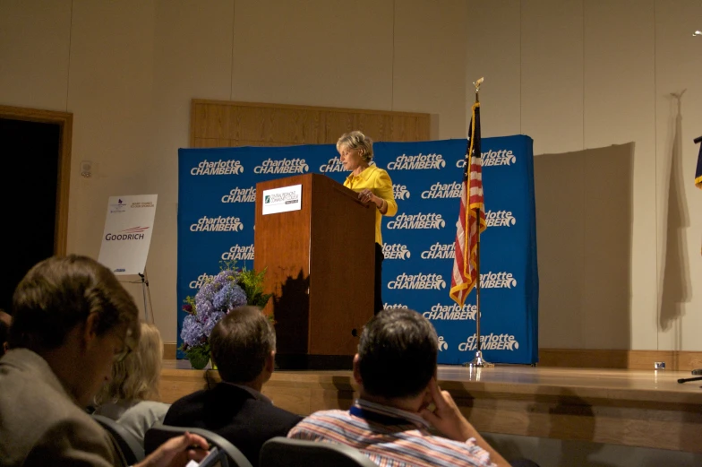 a woman is speaking from a podium at an event