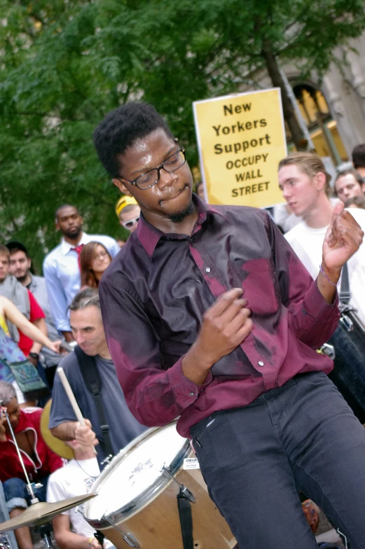 a young man playing drums on a crowded city street