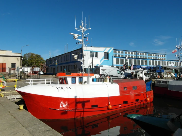 two small boats sit tied up at a dock