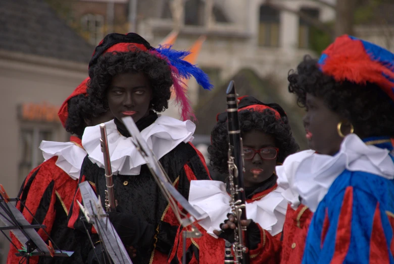 three women in red black and blue outfits playing instruments
