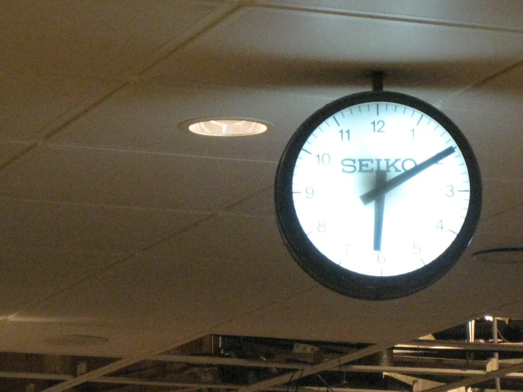 a clock hangs from the ceiling at a showroom