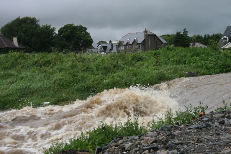 flooding waters rushing into the river onto a road