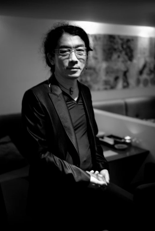 man standing near wooden table and black chair