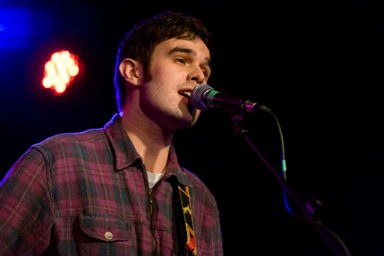 a man singing into a microphone on stage