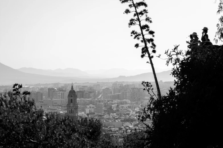 a man is standing on a hill overlooking a city