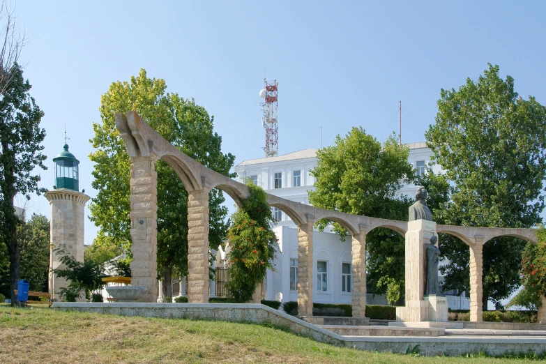 the building has arches and is in an area of grass with some bushes