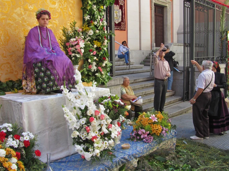 a group of people standing around a statue that has been placed in front of a building