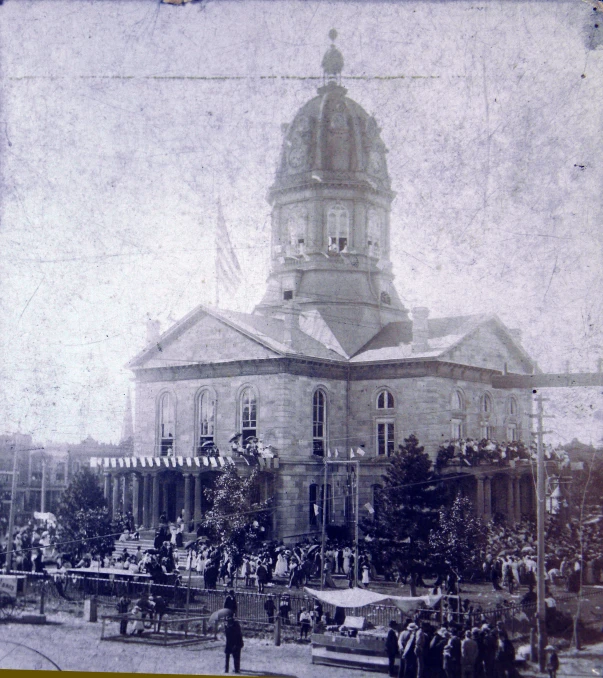 a black and white pograph of a large building with people in front of it