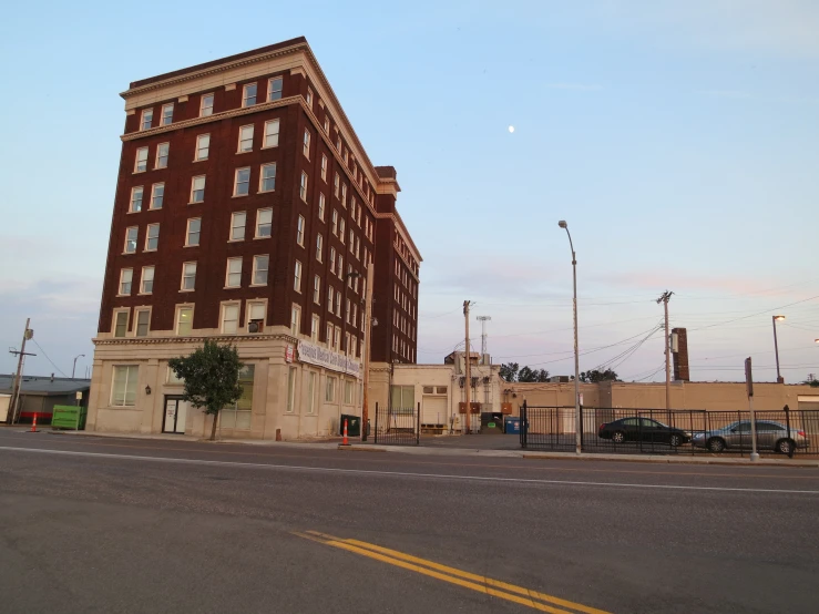 the view of an old brick building and traffic lights from across the street