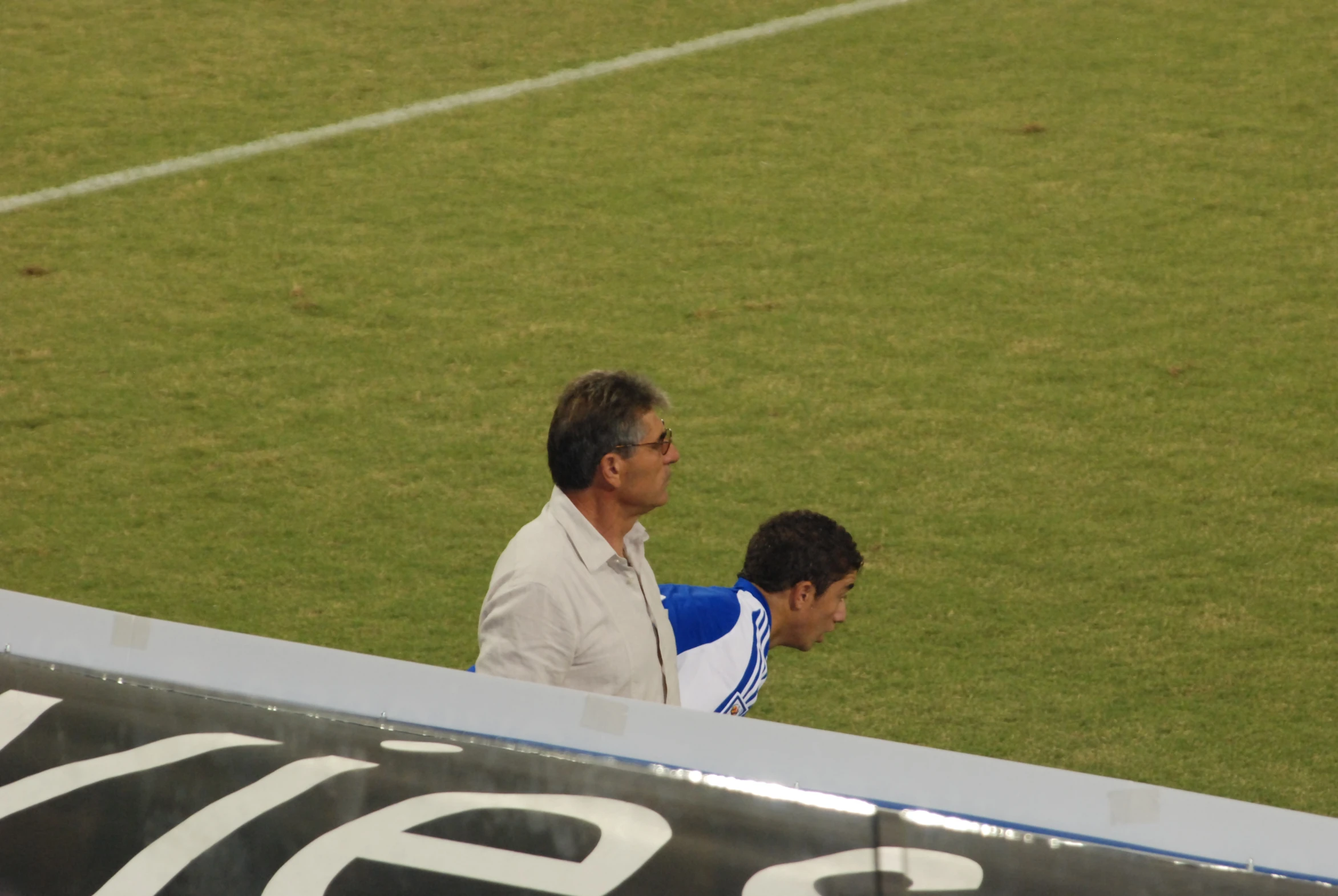two men on a soccer field sitting on the sidelines