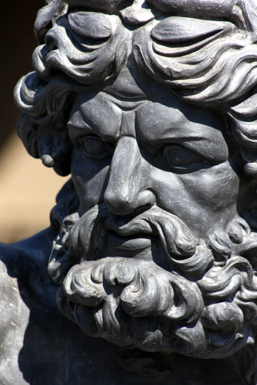 a stone head with curls is in the shape of a bust