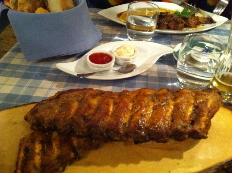 a large piece of steak on a table with fries and beer