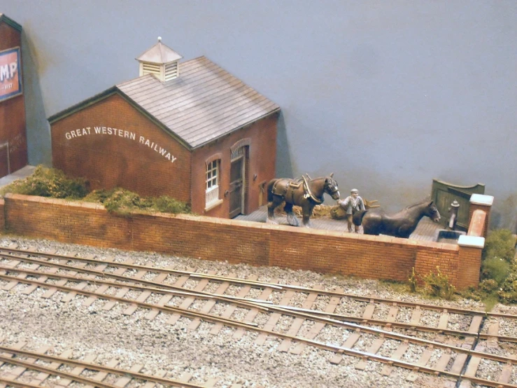 miniature train tracks surrounding a small model building