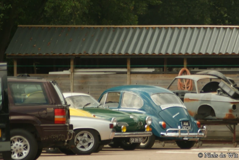 two old cars and a truck parked in a parking lot