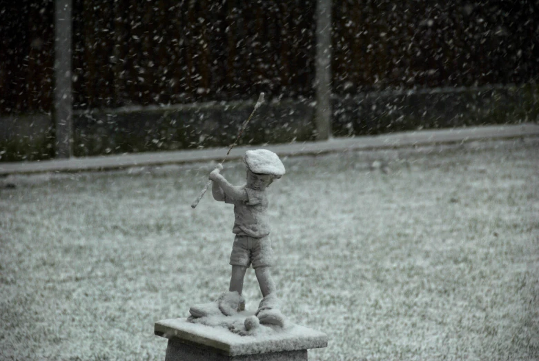 a statue of a little girl standing on a small box in the snow