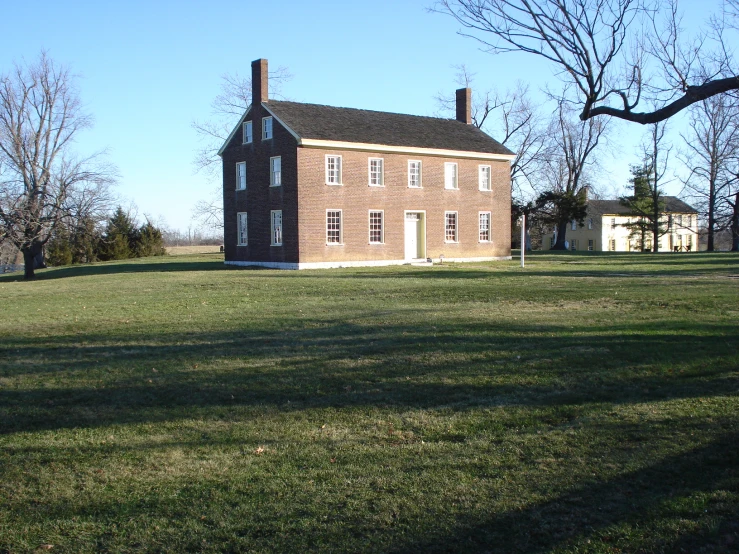 an old building in the middle of a grassy field