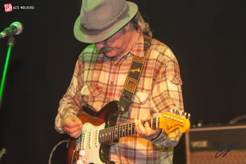 a man playing a white and brown guitar