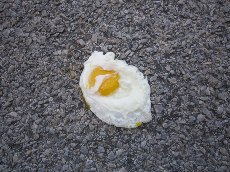 a fried egg with sauce on a rock surface