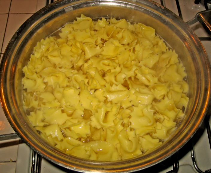 a bowl with macaroni and cheese cooking on the stove