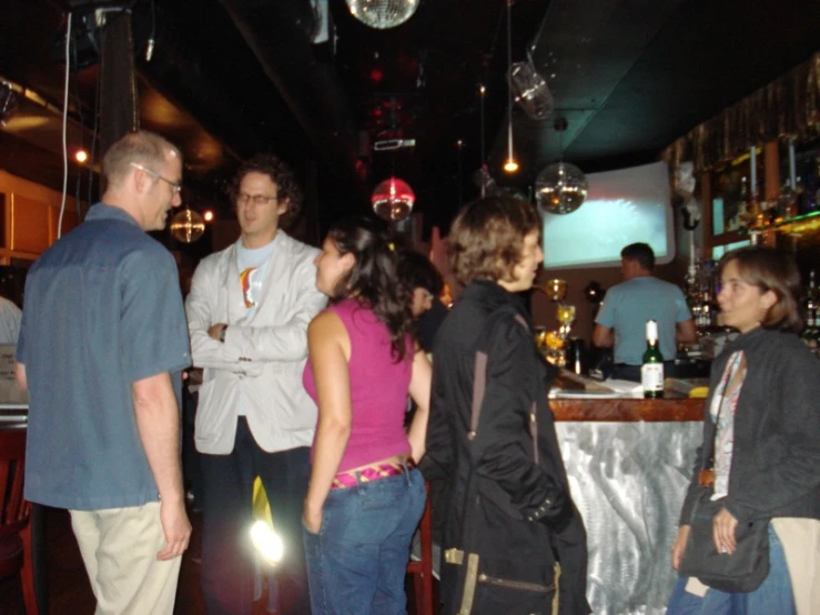 group of people standing around in a bar