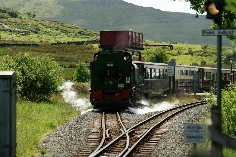 a steam locomotive pulling several carts on the tracks