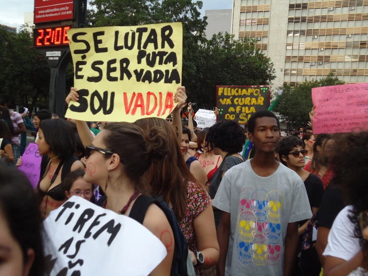 a protest at a city street holds a sign with words in spanish