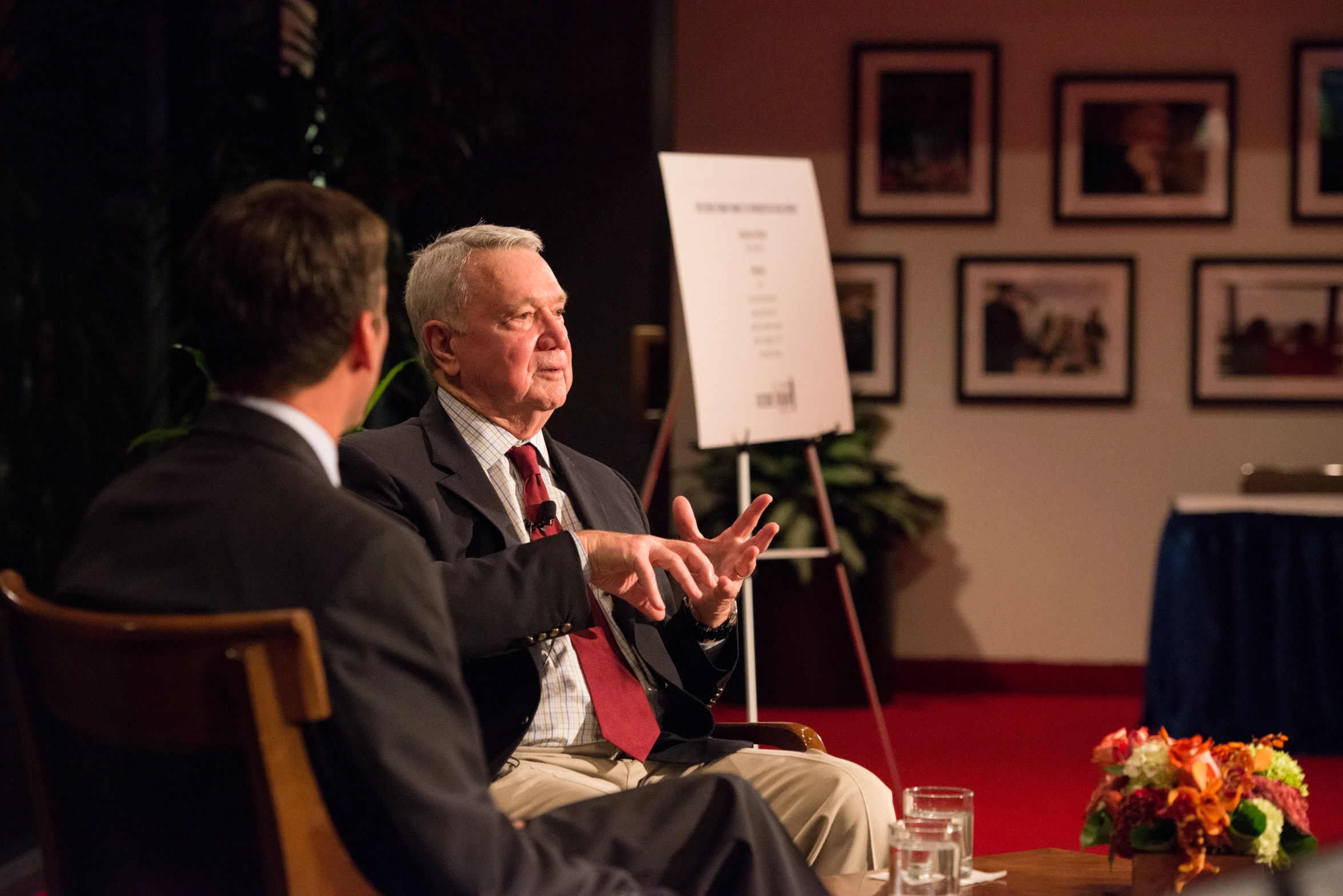 a man talks to another man in an auditorium