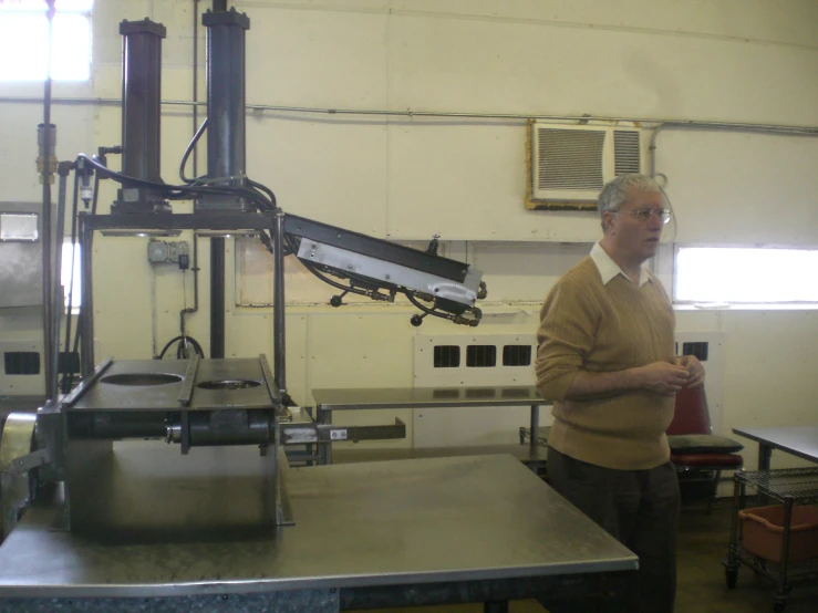 man standing in the background of machine in factory