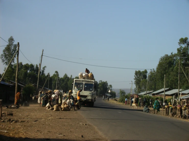 some people are walking down the street in front of a bus