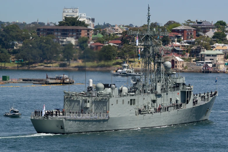 an battleship in a harbor with a boat in the background