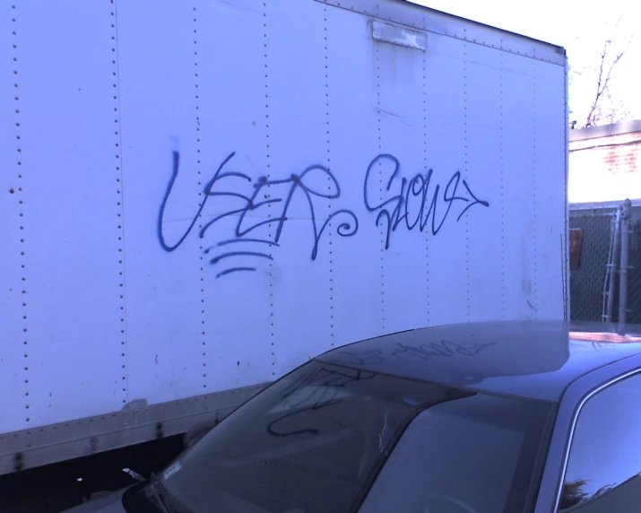 a car parked under a big white box truck