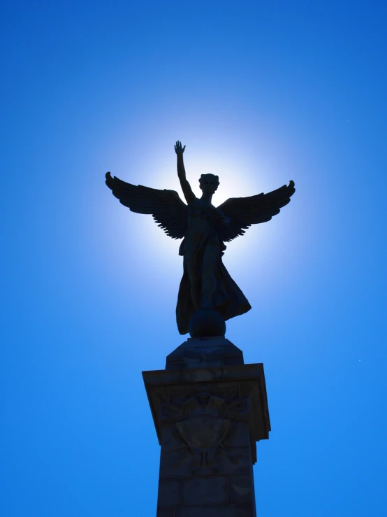 a statue with outstretched arms standing in the middle of a sun