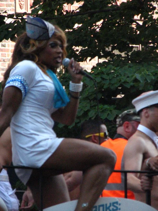 a woman in a sailor outfit singing into a microphone